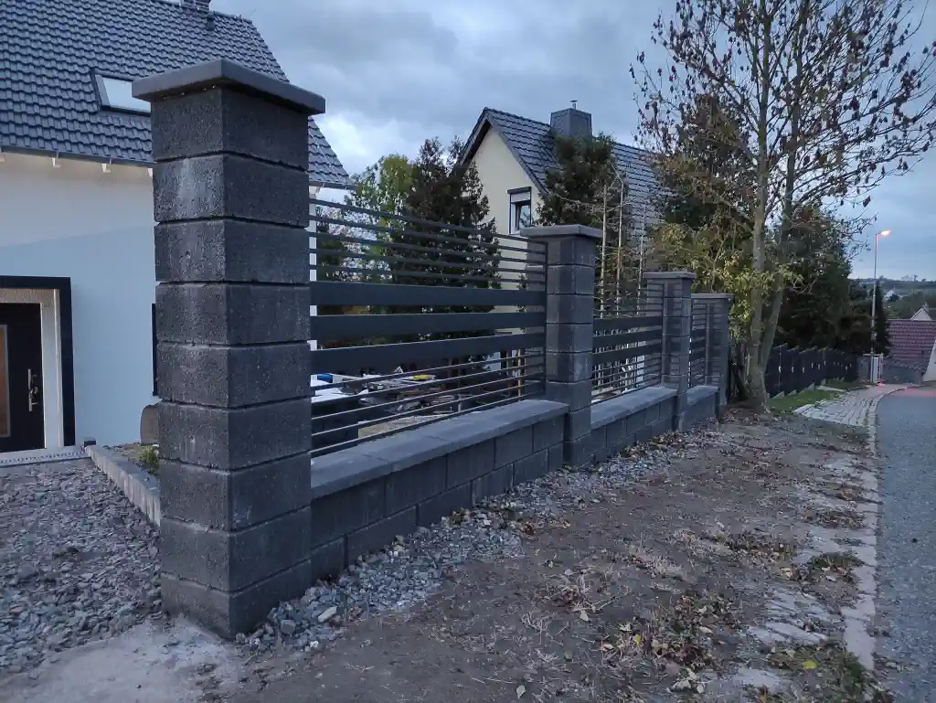 Moderner Zaun zwischen Betonsäulen montiert